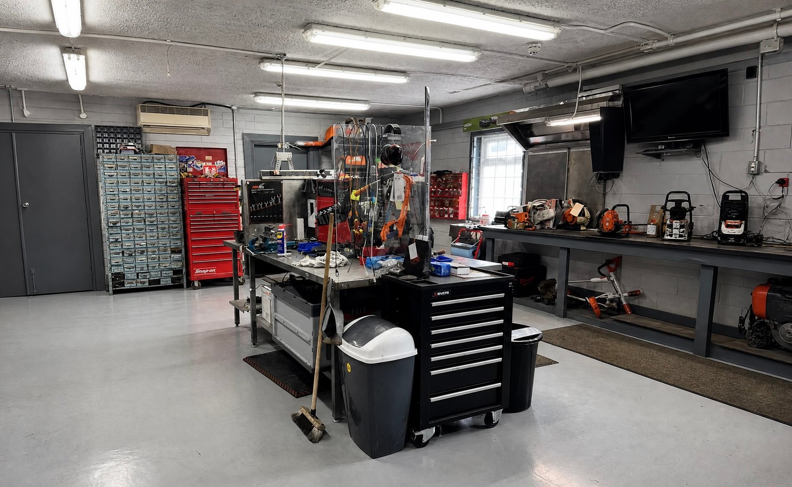 The workshop at MD Burke Ltd, with parts storage, a service bench and machines in for repair.